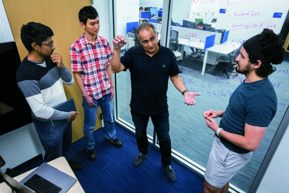 Tarokh discusses how to transfer knowledge between two similar scenarios with three of his lab fellows, from left to right, Shyam Venkatasubramanian, Xingzi Xu and Ahmed Aloui.