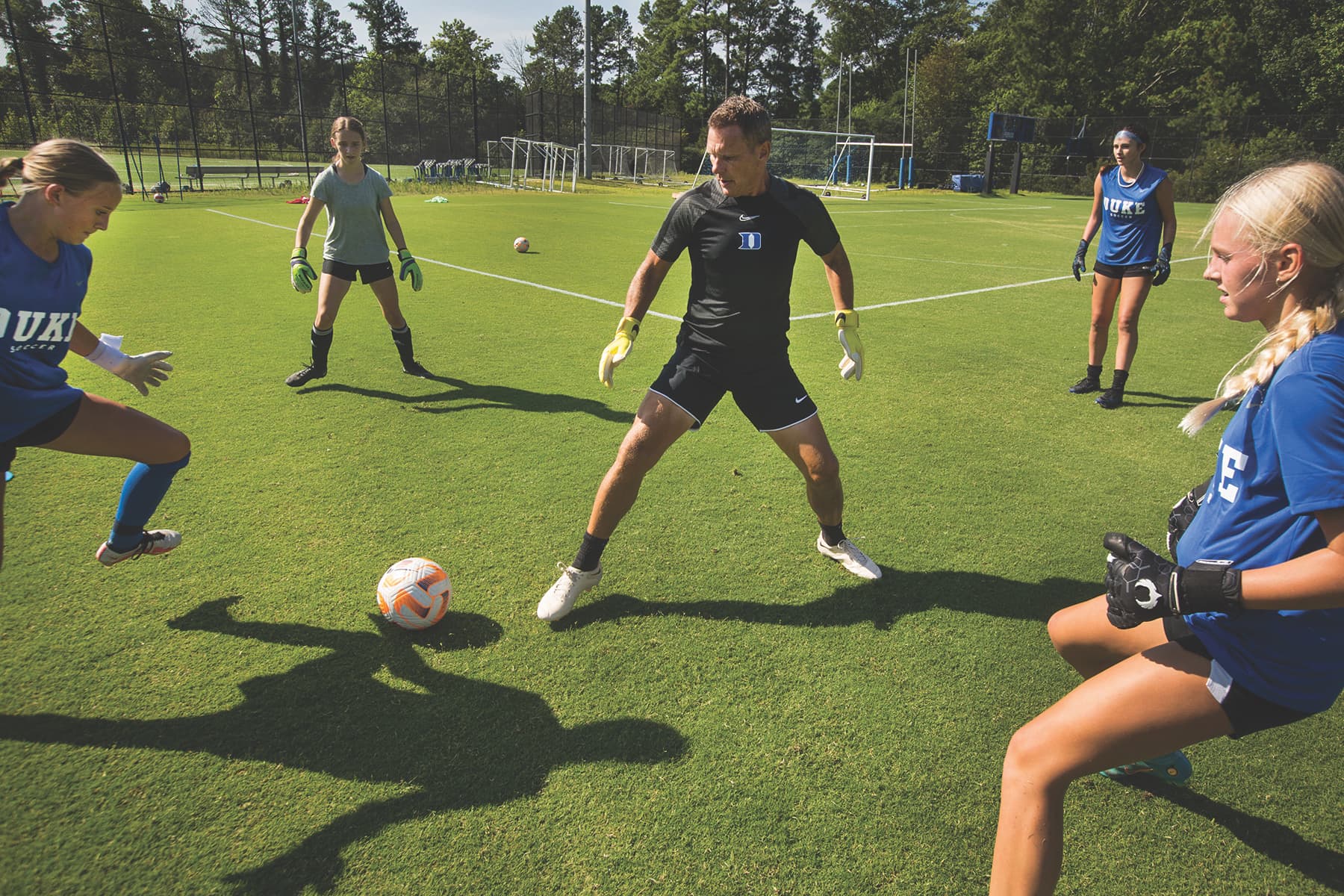 Assistant women's soccer coach Lane Davis takes campers through drills during Duke Soccer School for Girls Photo by Chris Hildreth