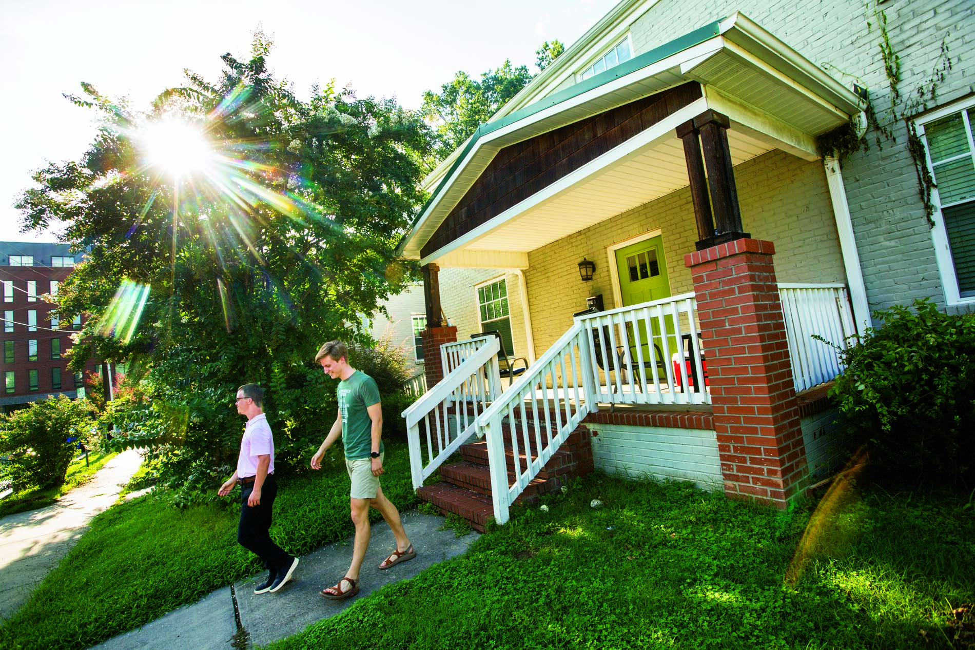 Two people walking on sidewalk