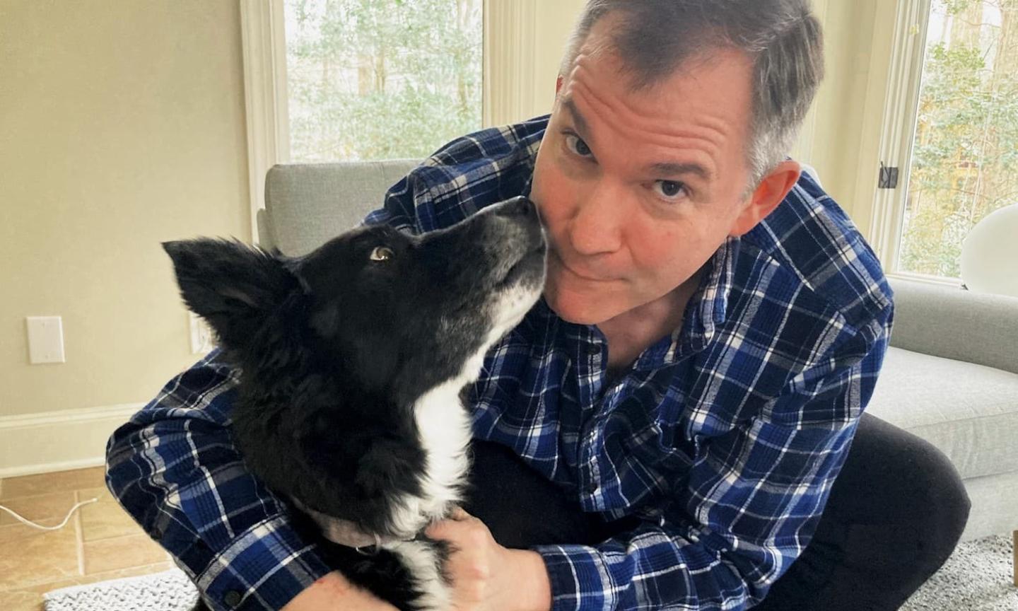 Frank Bruni in his Chapel Hill home with his beloved Regan, a constant companion on outdoor adventures.