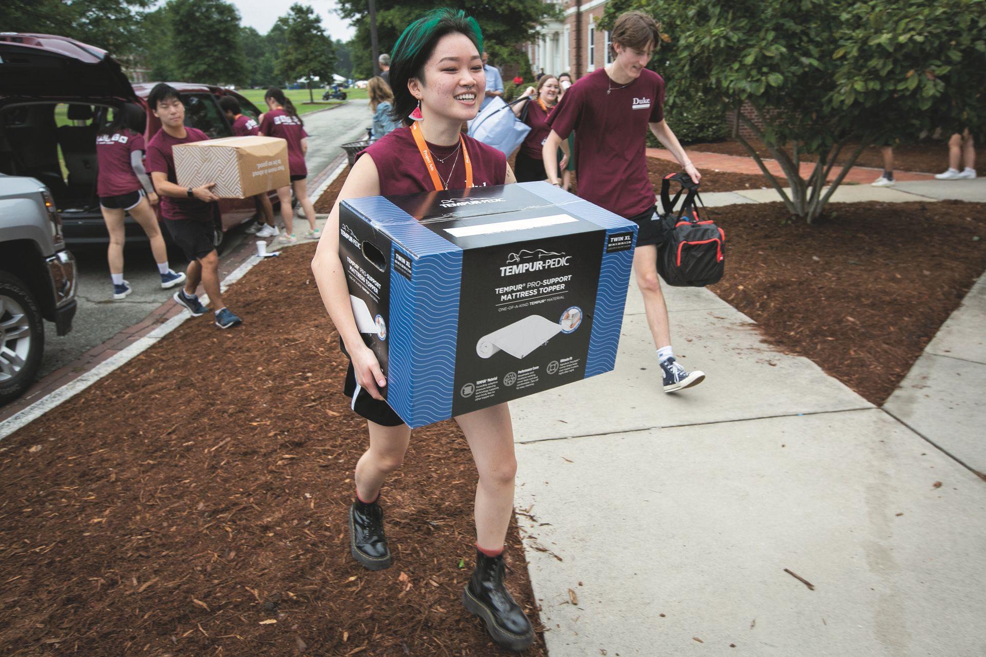 THUMBNAIL: Students and volunteers assisting with freshmen move-ins.